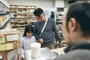 Father and daughter checking out at store