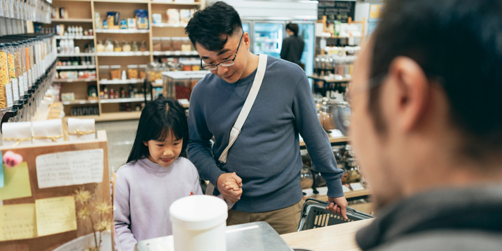 Father and daughter checking out at store