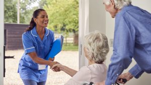 Nurse greeting elderly couple at assisted living facility