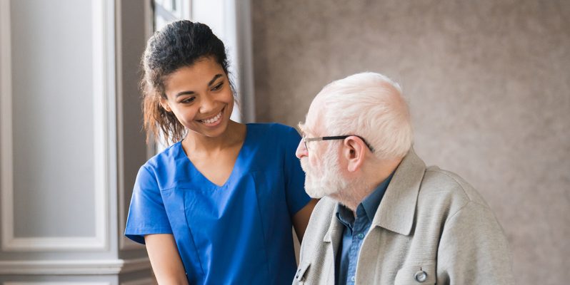 Nurse helping elderly man at nursing home