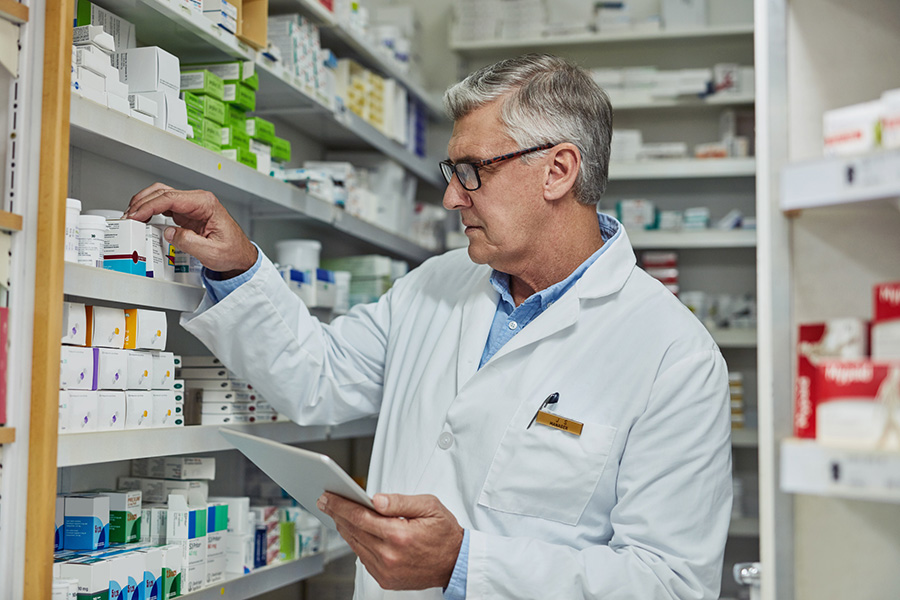 Pharmacist looking at products on shelves and day dreaming about succession planning