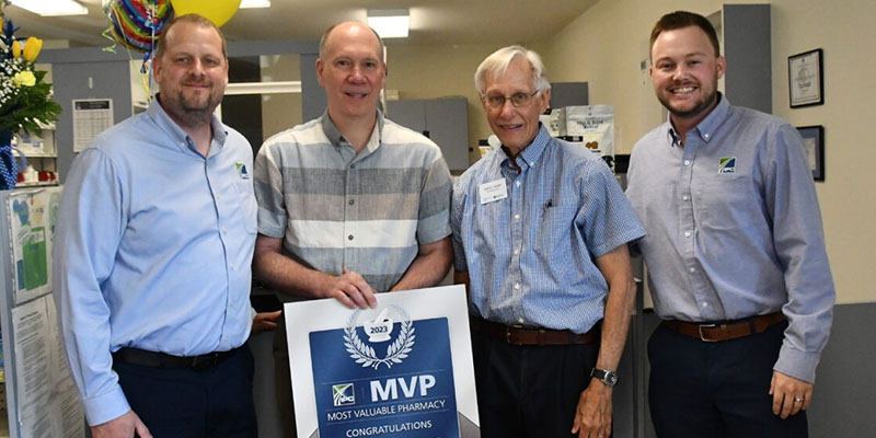 Scott Wittnebel and Tanner Boos of IPC present MVP award to Scott and Darryl of Cains Drug Store in Vandalia IL