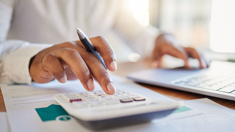 a man on a computer and calculator working out his business budget strategy