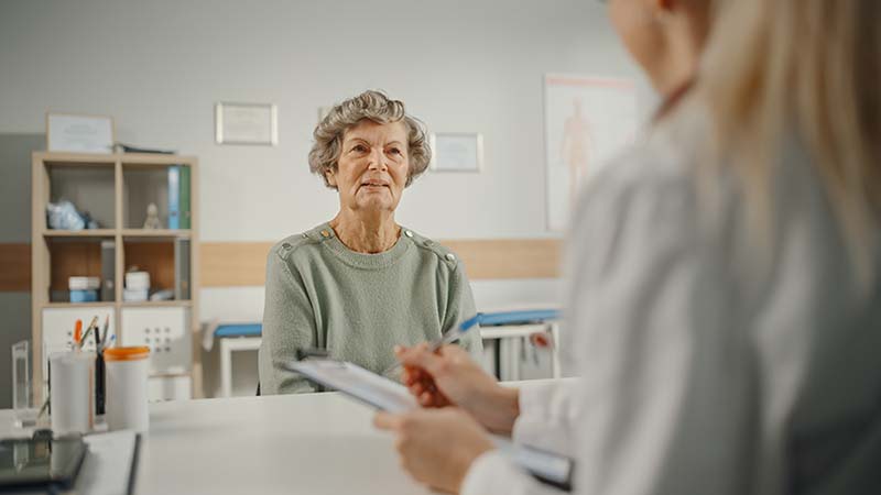 Woman and pharmacist going over Medicare open enrollment options