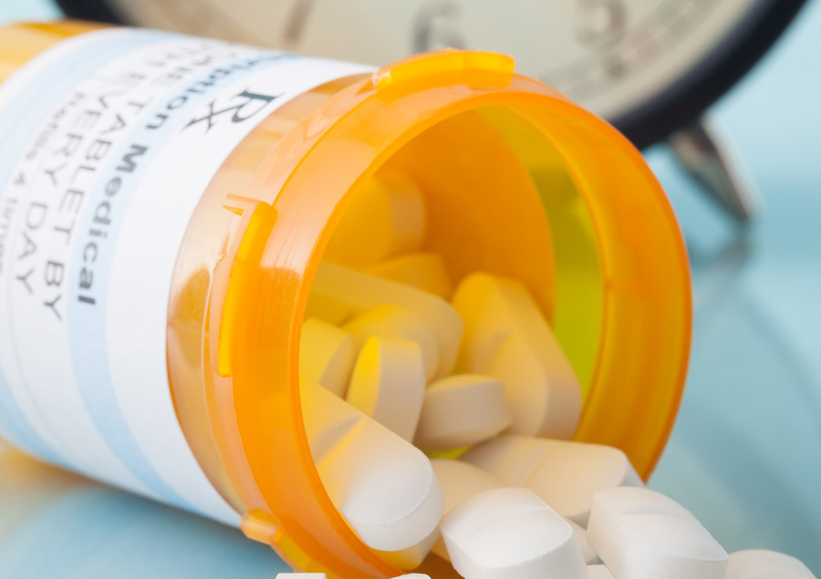 Pill bottle in front of clock in Independent Pharmacy