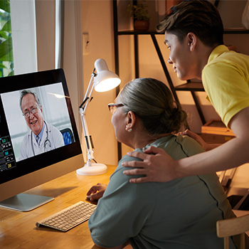 man with mother talking to doctor on a computer