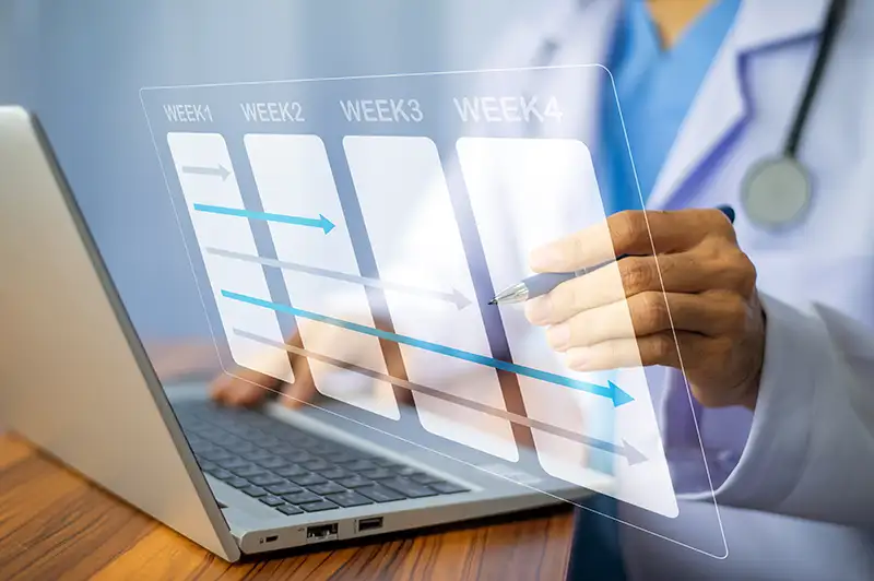 doctor planning out week in front of laptop
