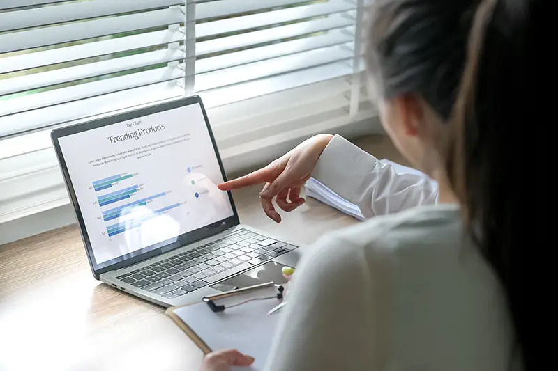 pharmacist at laptop going over reports
