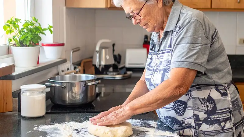 elderly woman making dough