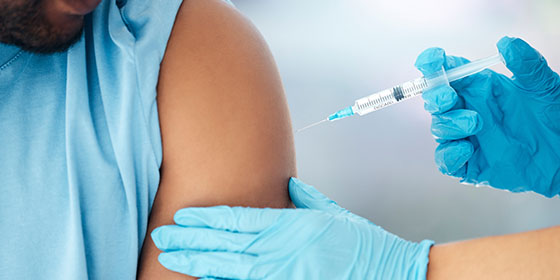 pharmacist administering vaccine to patient