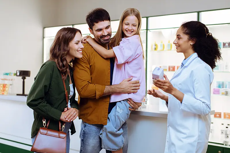 Pharmacist consulting with a family and reviewing medication at an independent pharmacy, illustrating personalized care and patient support